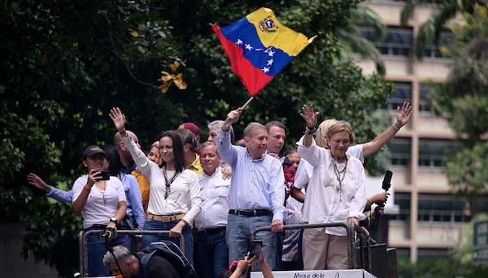 FILE PHOTO: Opposition leader Maria Corina Machado and opposition candidate Edmundo Gonzalez wave as they address supporters, in Caracas, Venezuela July 30, 2024. REUTERS/Gaby Oraa/File Photo